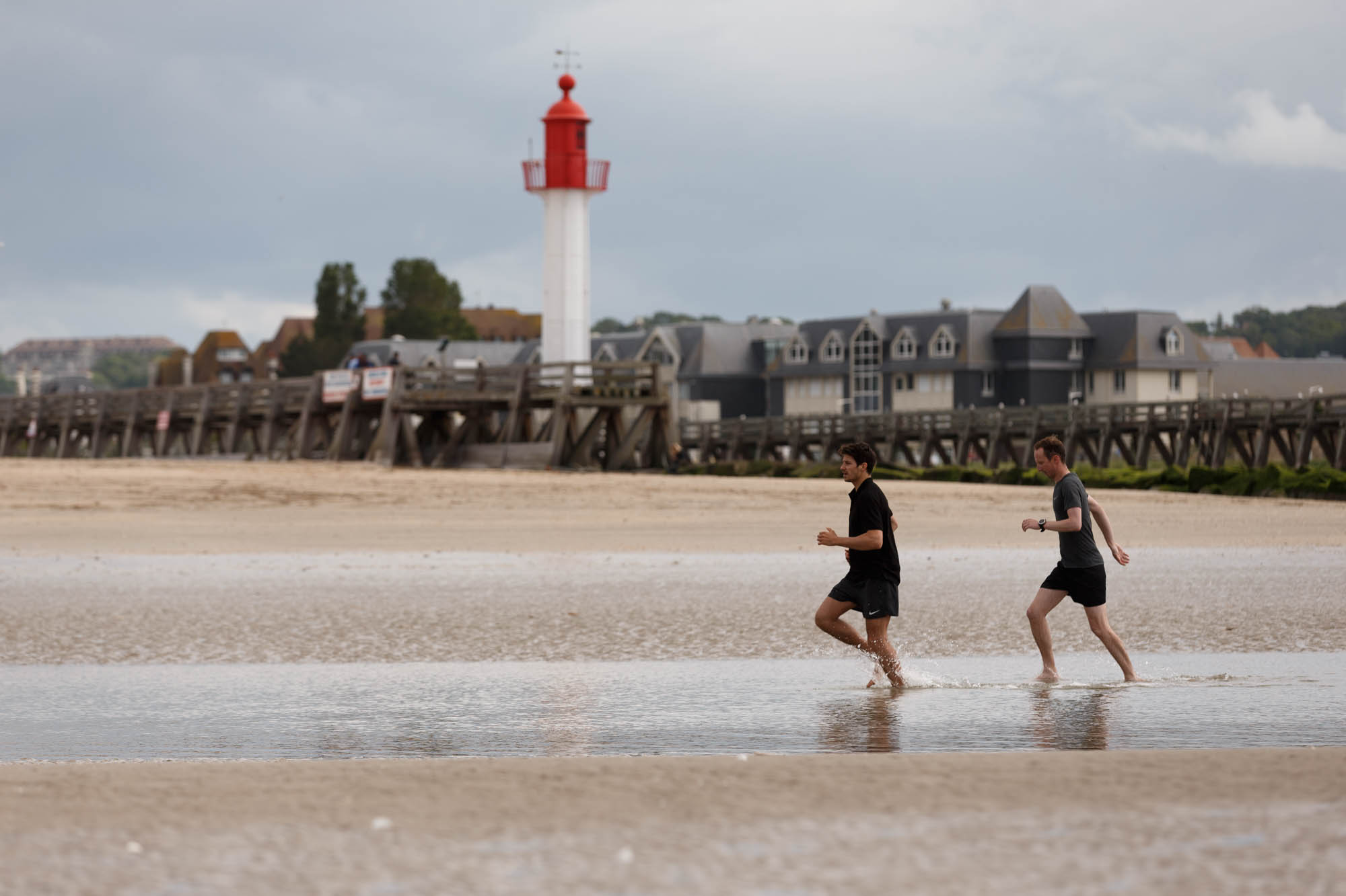 Enfants courant sur la plage devant le phare de Trouville — Les Cures Marines, Trouville, photo David Morganti