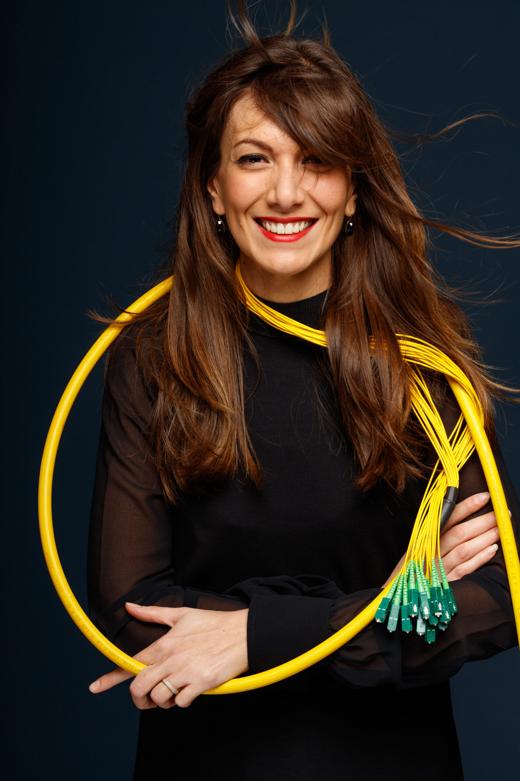 Collaboratrice tenant une boucle de fibre optique en studio — Altitude Infra, photo David Morganti