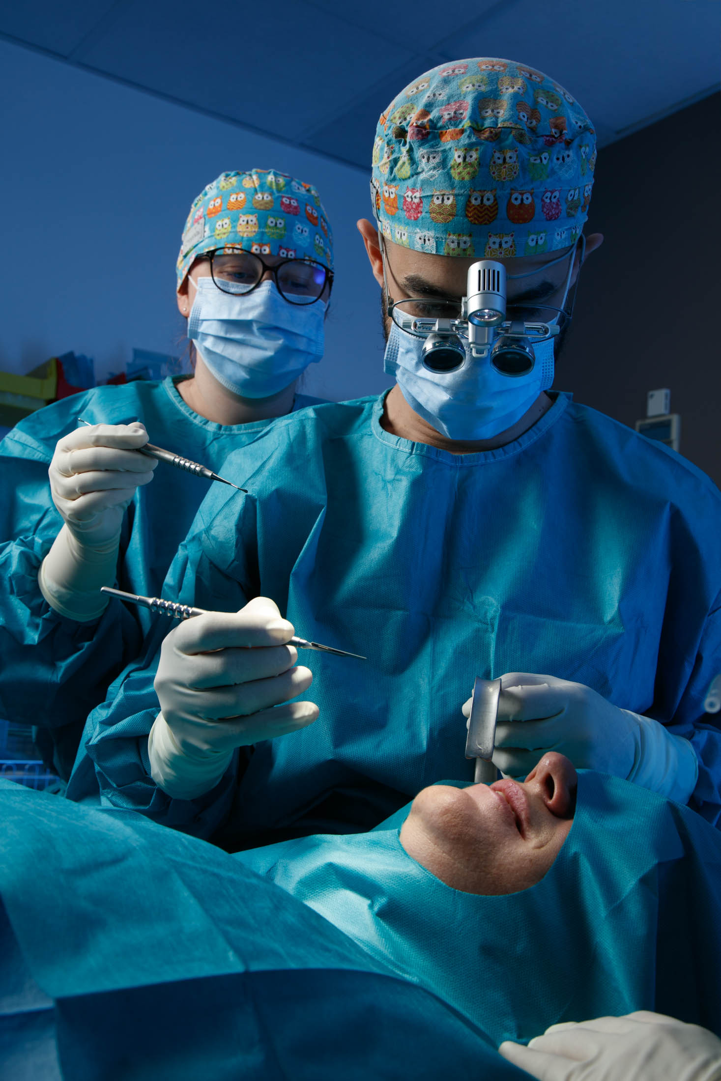 Chirurgien-dentiste et assistante en intervention au bloc, loupes et éclairage frontal — photographe santé David Morganti