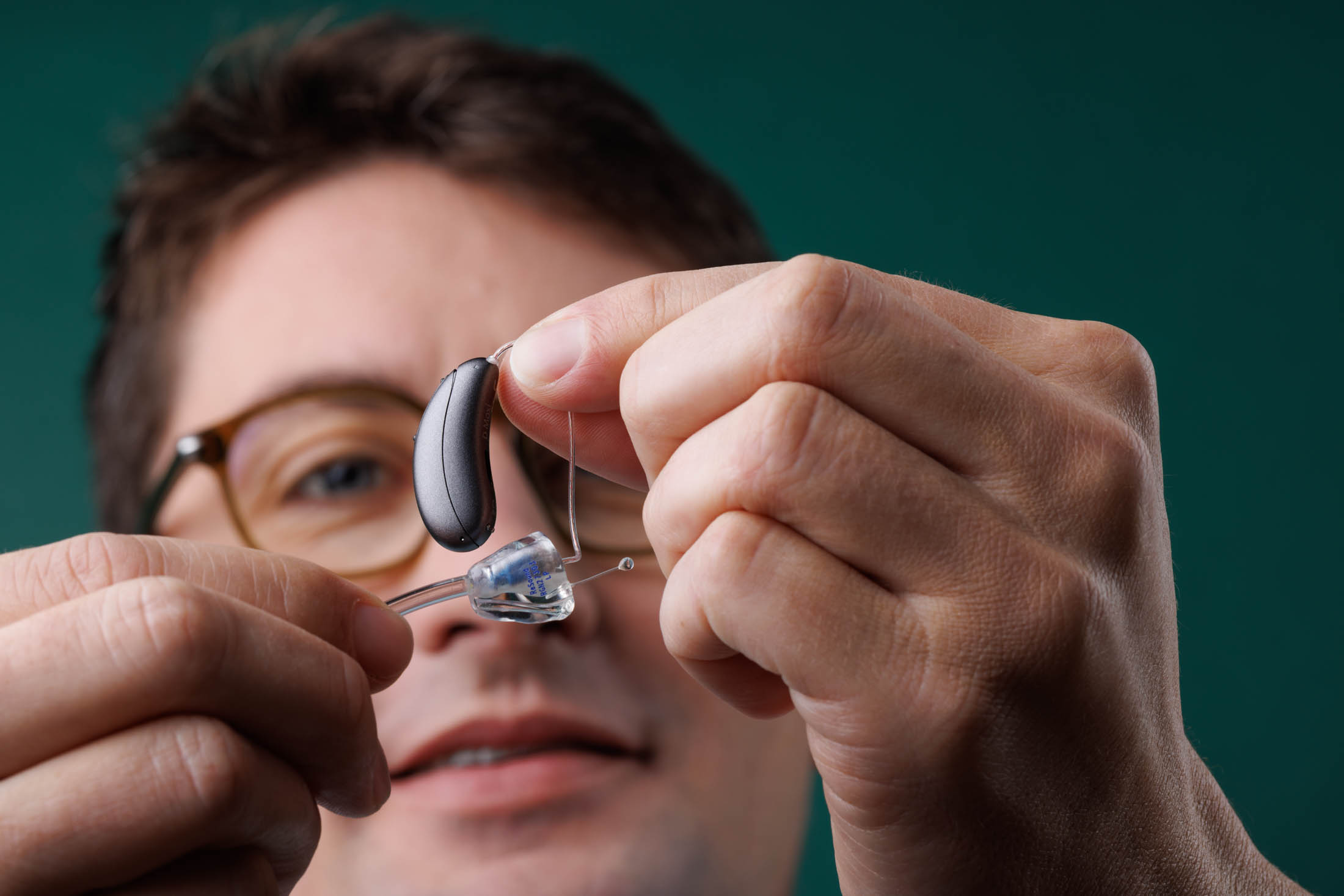 Audioprothésiste présentant un appareil auditif sur mesure — Dyapason, photo David Morganti