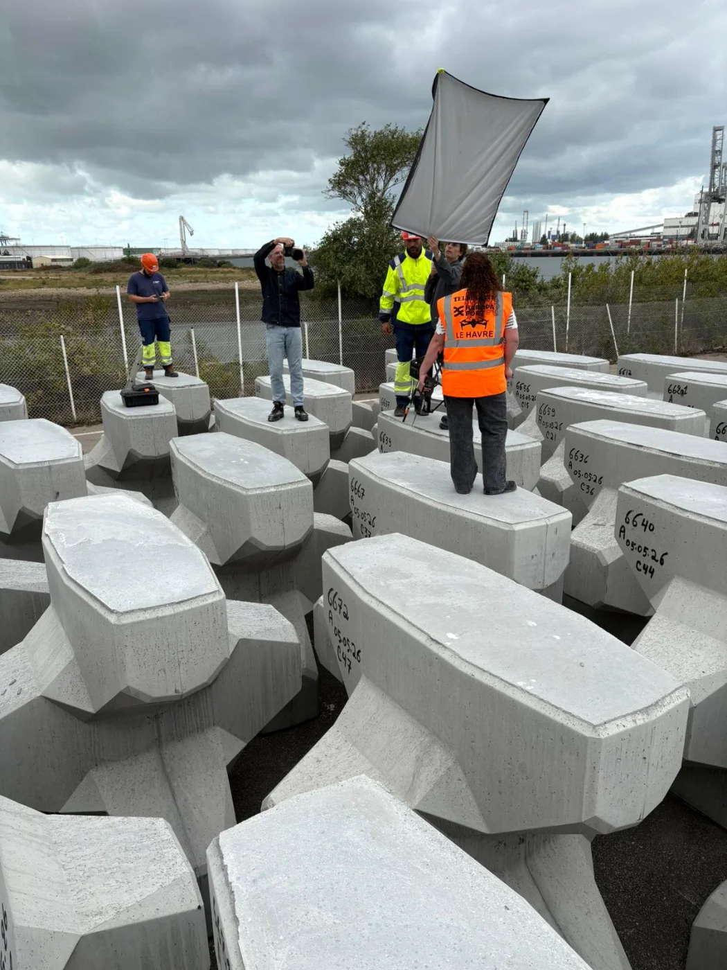 Coulisses : l’équipe installe un réflecteur dans le champ d’accropodes du chantier de la Chatière, Le Havre — David Morganti