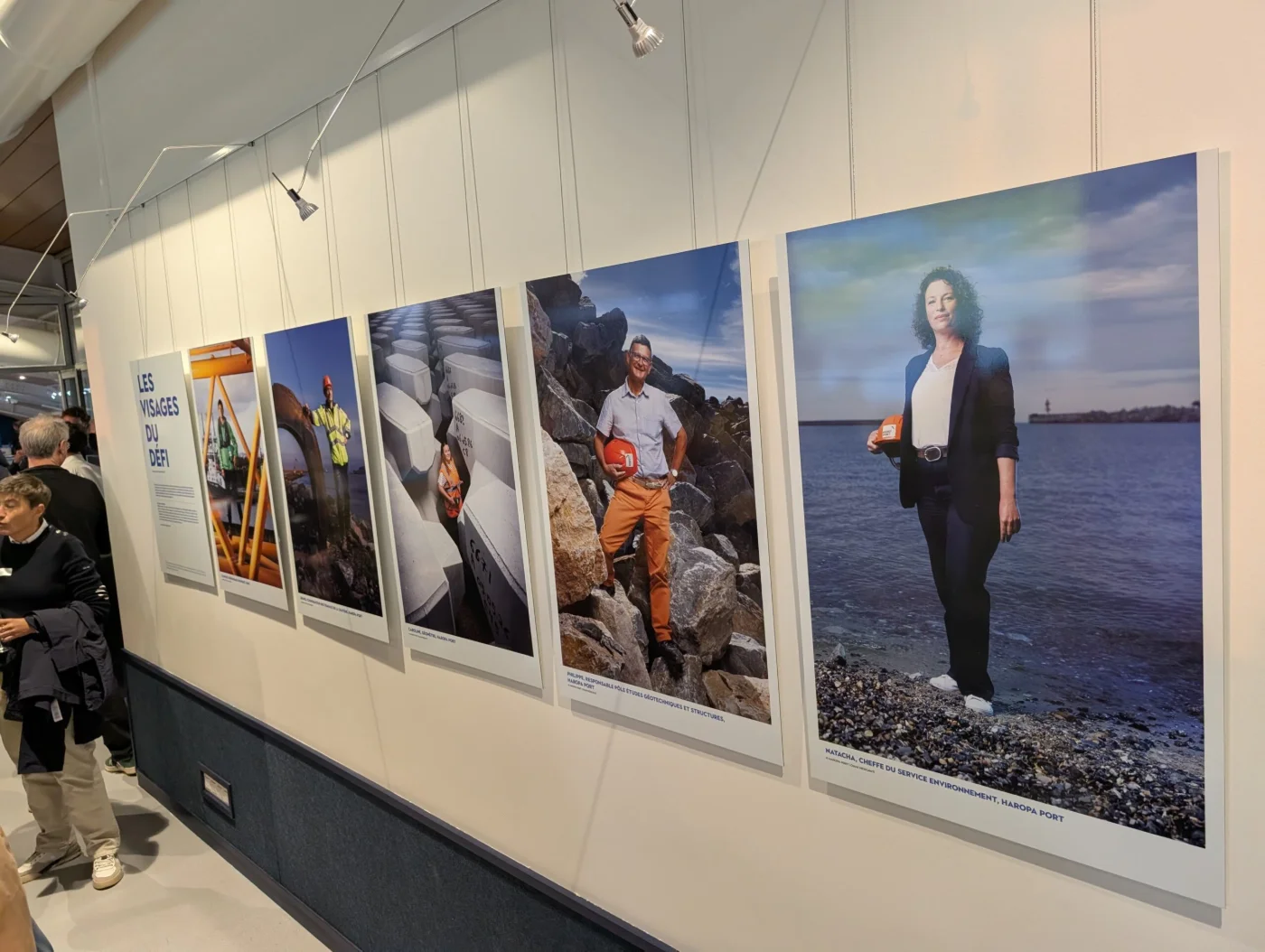 Le panneau d’introduction « Les visages du défi » et les premiers portraits accrochés, Le Havre Port Center